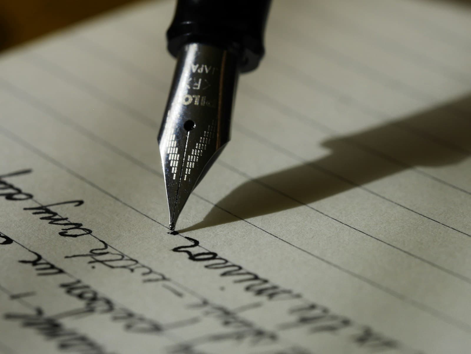 Writer at work - open book, pen and notebook on a wooden desk